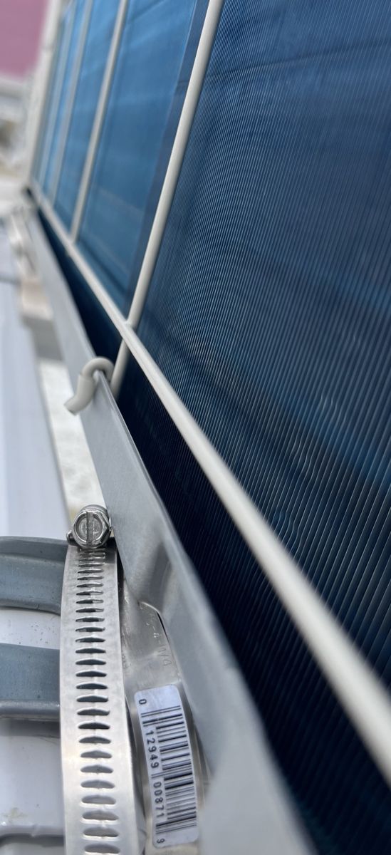 Steel band clamp as a second hold-down, coil guard installed